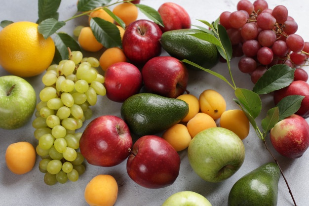 fruit-background-with-apples-grapes-apricots-peaches-avocado_181627-342