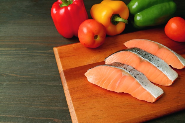 uncooked-raw-sliced-salmon-wooden-cutting-board-with-fresh-colorful-vegetables_76000-2690