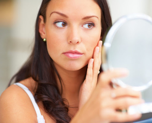 Closeup portrait of young lady holding a mirror