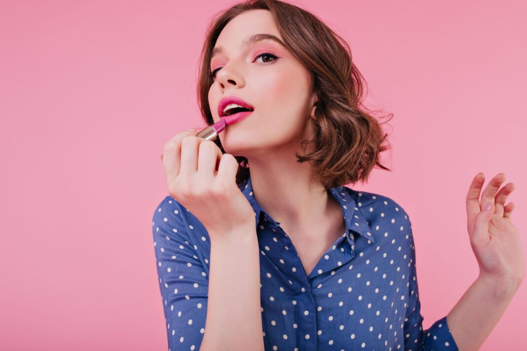 graceful-woman-doing-lips-makeup-bright-wall-indoor-portrait-magnificent-short-haired-girl-posing-with-lipstick-scaled